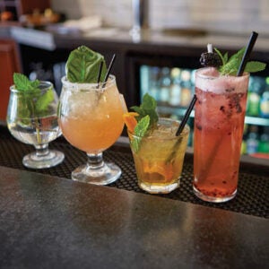 Four cocktails on a bar