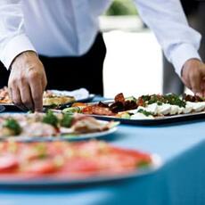 A caterer setting out trays of food