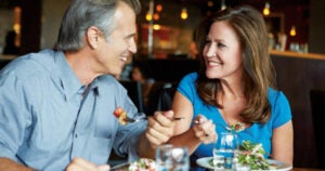 Middle aged man and woman eating